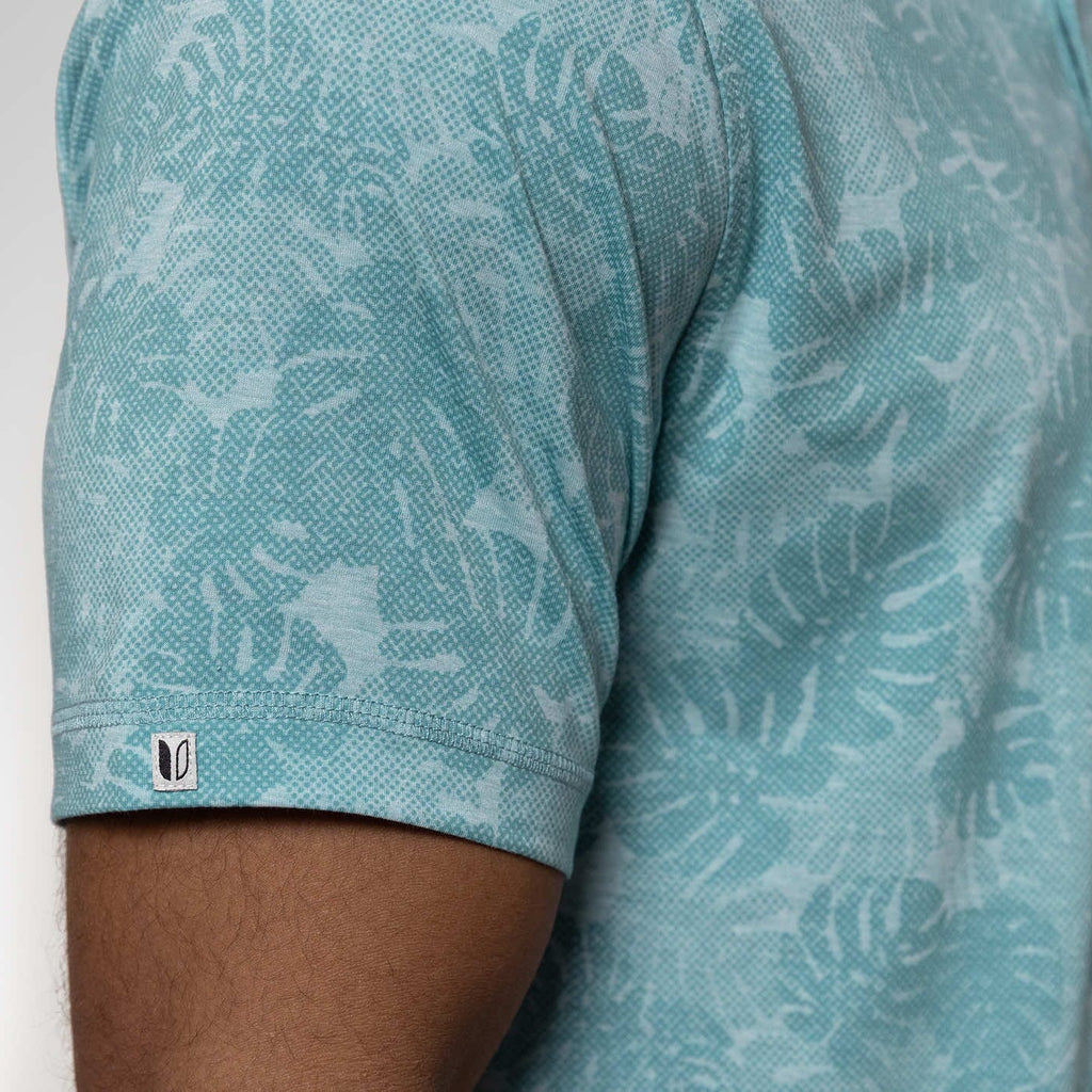 Teal patterned shirt with a brand logo on a white background