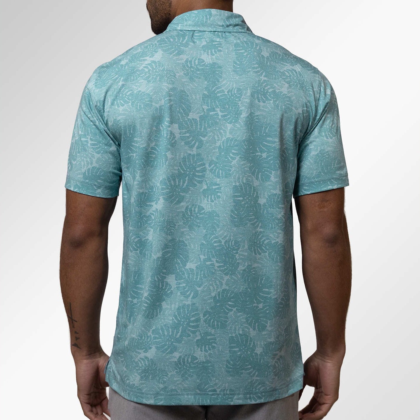 Man wearing a teal patterned shirt on a white background