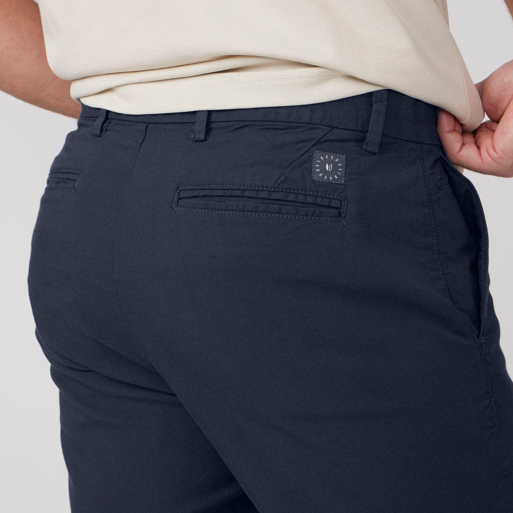 Navy pants with a brand logo on the pocket against a neutral background